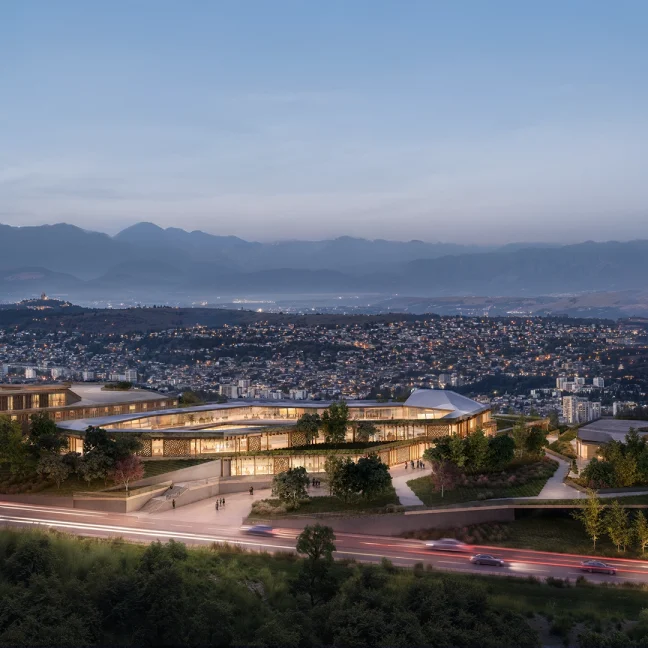 The school campus lit at blue hour on the ridge above Tbilisi